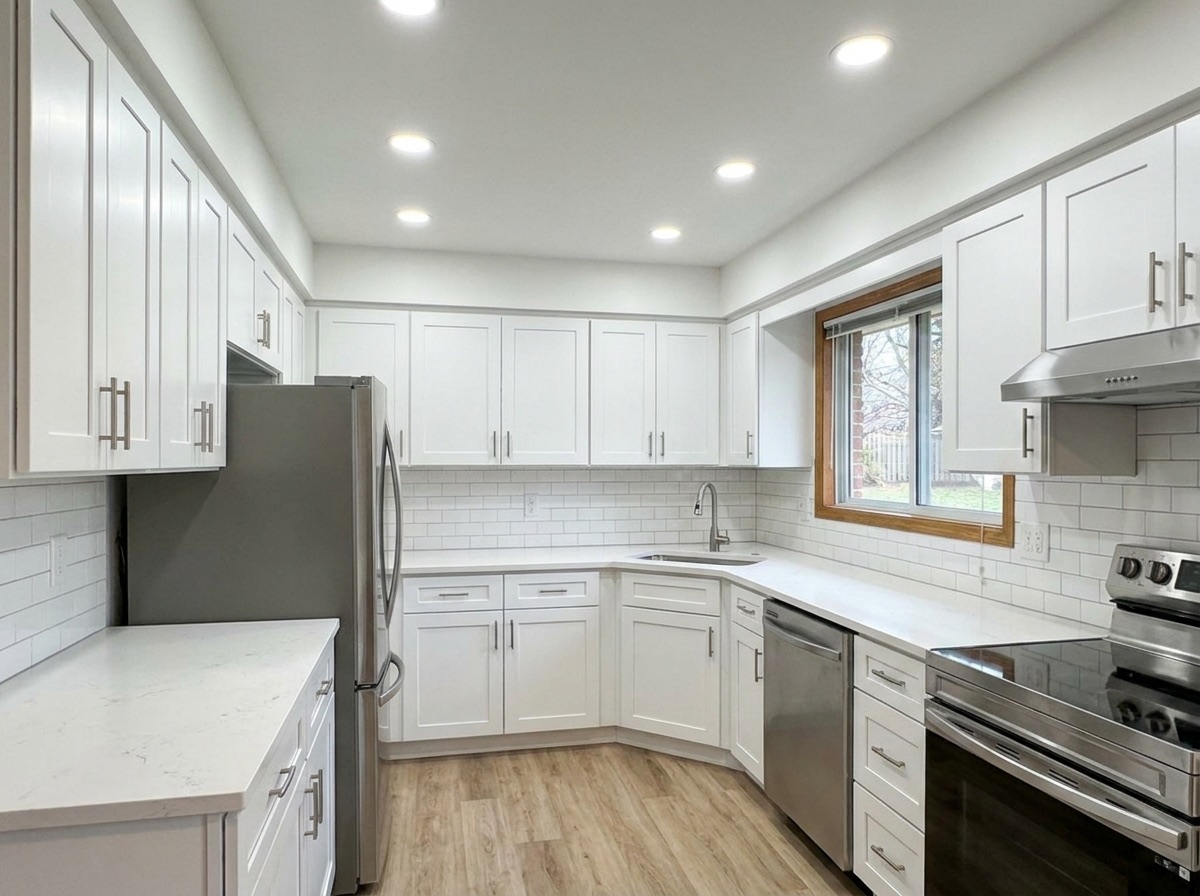 Remodeled kitchen with white shaker cabinets and quartz counters